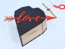 Caja de Regalo en Forma de Corazón con Flecha Vector Láser